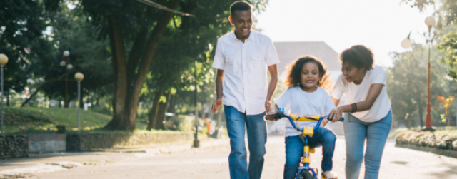 Couple teaching their child how to bike