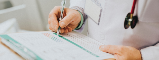 Doctor writing on a clipboard